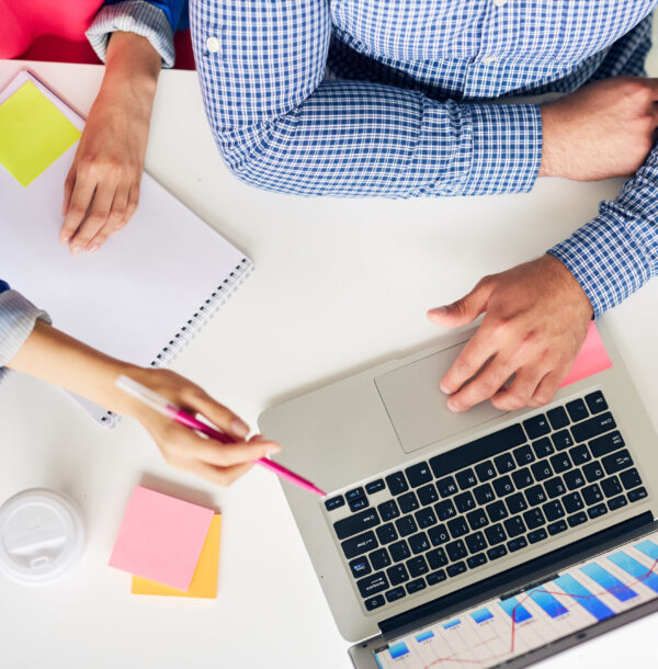 One of analysts making presentation in laptop to her colleague at meeting