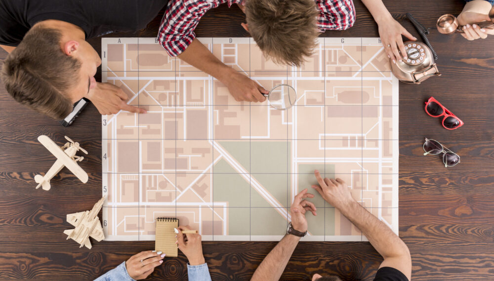 Friends sitting together and planning their travel with a map