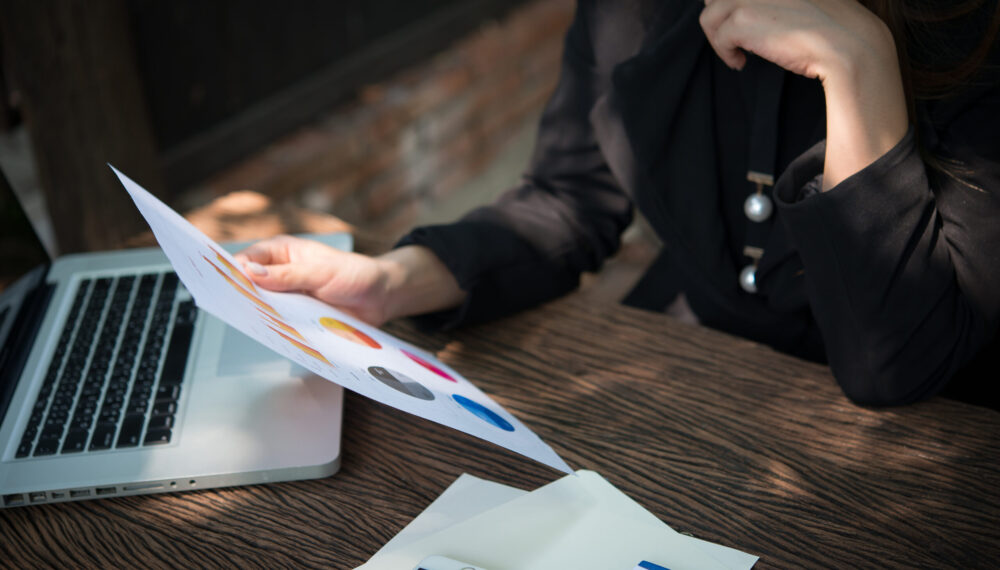 business woman working with documents graphs ,analyzing investment chart working in office.